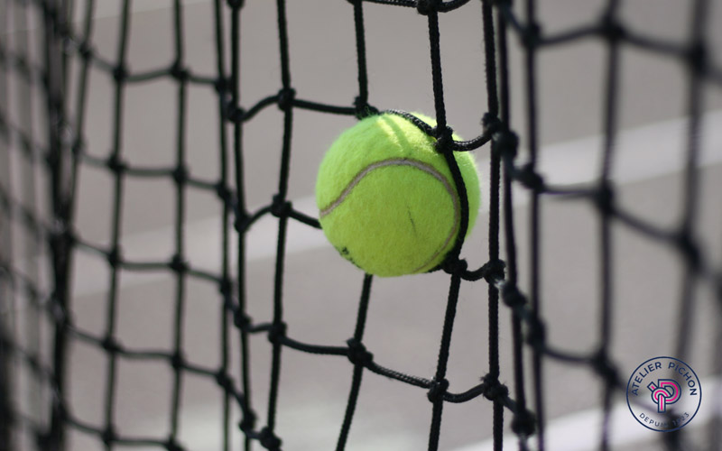 L'image présente un filet spécialement conçu pour les courts de tennis, un équipement essentiel pour la pratique de ce sport. Fabriqué à partir de matériaux résistants aux intempéries, ce filet est facile à installer et à enlever. Il est adapté aux dimensions réglementaires des courts de tennis, offrant ainsi une surface de jeu équitable et sécurisée pour les joueurs.